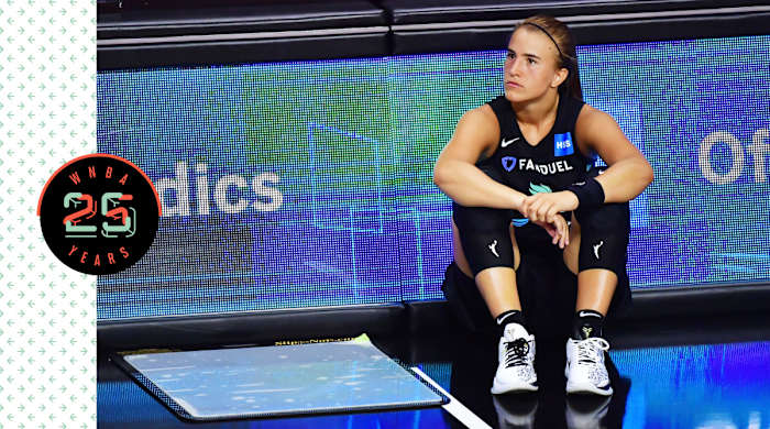 Sabrina Ionescu sitting on the court, looking pensive